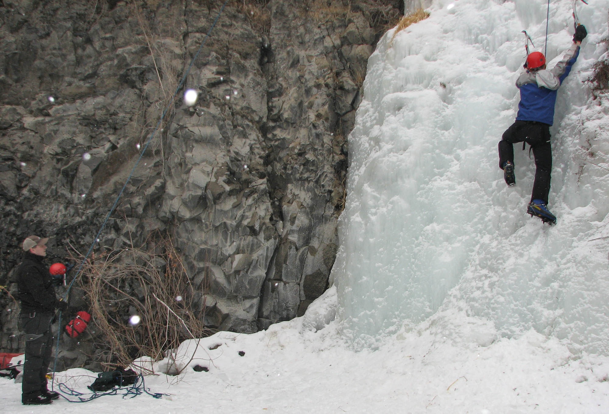 Making his way up a frozen waterfall in the Banks Lake Wildlife Recreation Area, 2nd Lt. Stuart Jessup, 92nd Communication Squadron executive office and a participant in the Outdoor Recreation Connection ice climbing trip, relies on ORC volunteer Dave Killpack to belay, or control the climbing rope, during an ice climbing trip with the ORC Feb. 14. (U.S. Air Force Photo / Senior Airman Kali L. Gradishar)