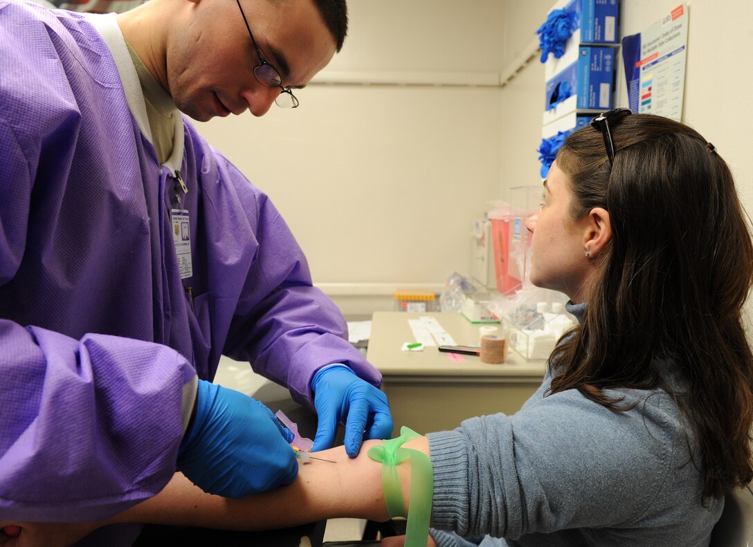 LANGLEY AIR FORCE BASE, Va. -- Airman 1st Class Donald Chapman, 1st Inpatient Squadron laboratory technician, draws blood from Capt. Christine Bolton, 1st Fighter Wing Air Force Smart Operations for the 21st Century officer in charge Feb. 18.  The laboratory technicians test samples provided by patients for diseases. (U.S. Air Force photo/Airman 1st Class Zachary Wolf)
