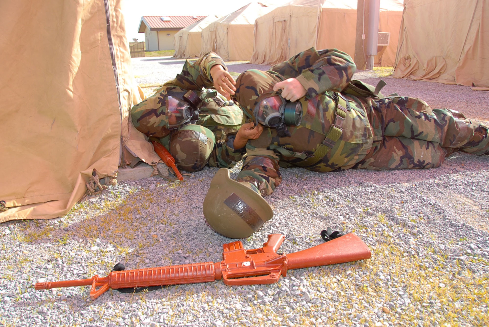 Tech. Sgt. Gary Beckford (left) helps Master Sgt. Ed Hancuff with his gas mask at “Blue Thunder” during a deployment exercise Feb. 12.  Both Sergeants Beckford and Hancuff are members of the 42nd Medical Group. (Air Force photo by Jamie Pitcher)