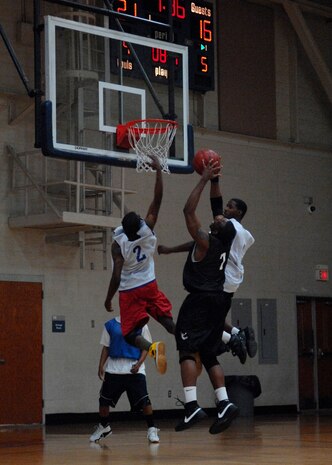 LRS 2 defenders attempt to block Lamar Hancock as he shoots the ball during the intramural basketball game at the Fitness and Sports Center Feb. 18. FSS dominated LRS 2 72-25. Hancock is a member of the 437th Force Support Squadron. (U.S. Air Force photo/Senior Airman Katie Gieratz) 