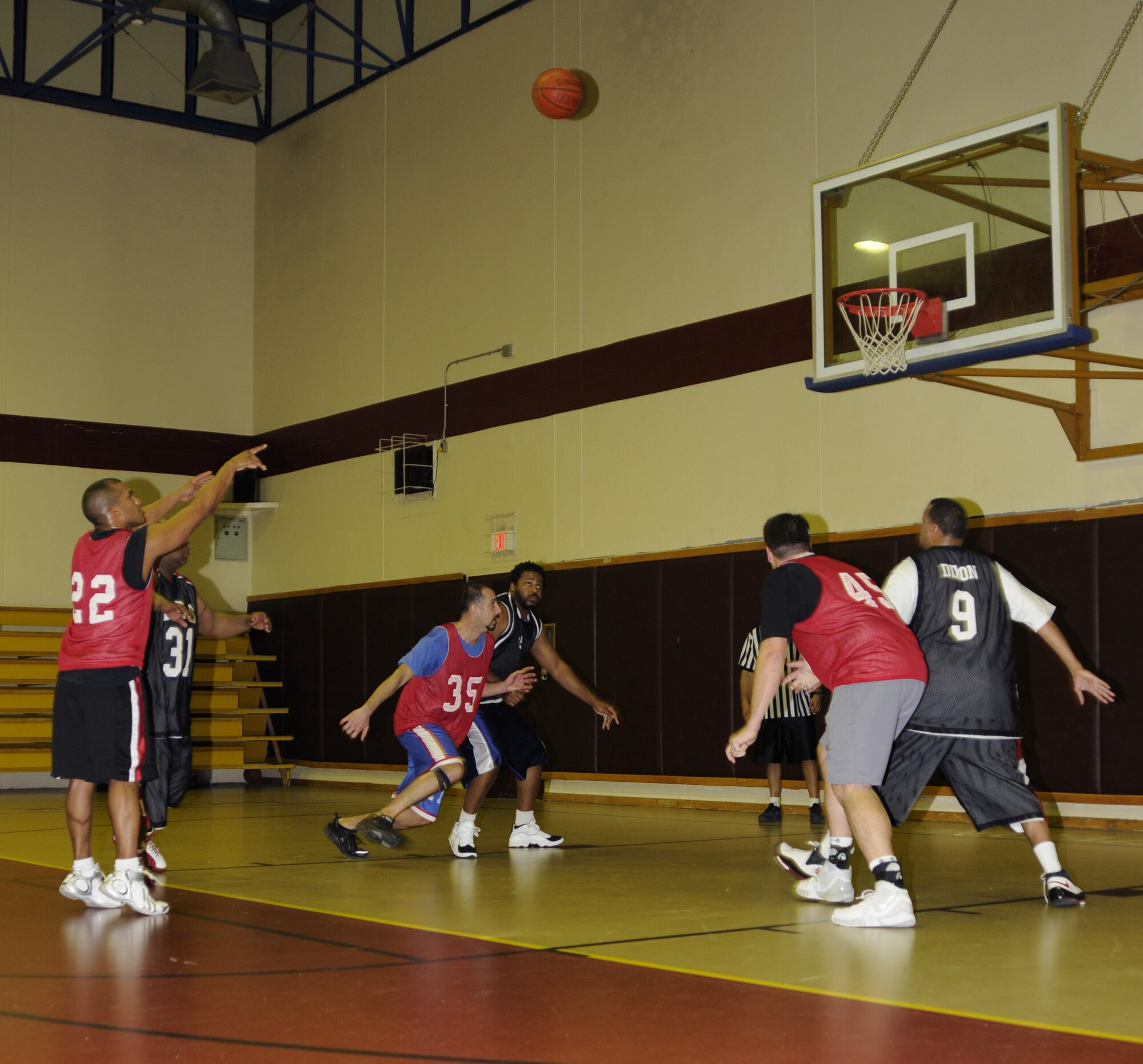 Adanzy Hart, Department of Defense Dependents School guard, shoots his second foul shot as members from both teams rush the key for the rebound Feb. 17 at the Incirlik Fitness Center during the DoDDs and 39th Logistics Readiness Squadron over-30 championship basketball game.  DoDDs beat out 39 LRS 62 - 54 for the title. (U.S. Air Force photo by Airman 1st Class Amber Russell)