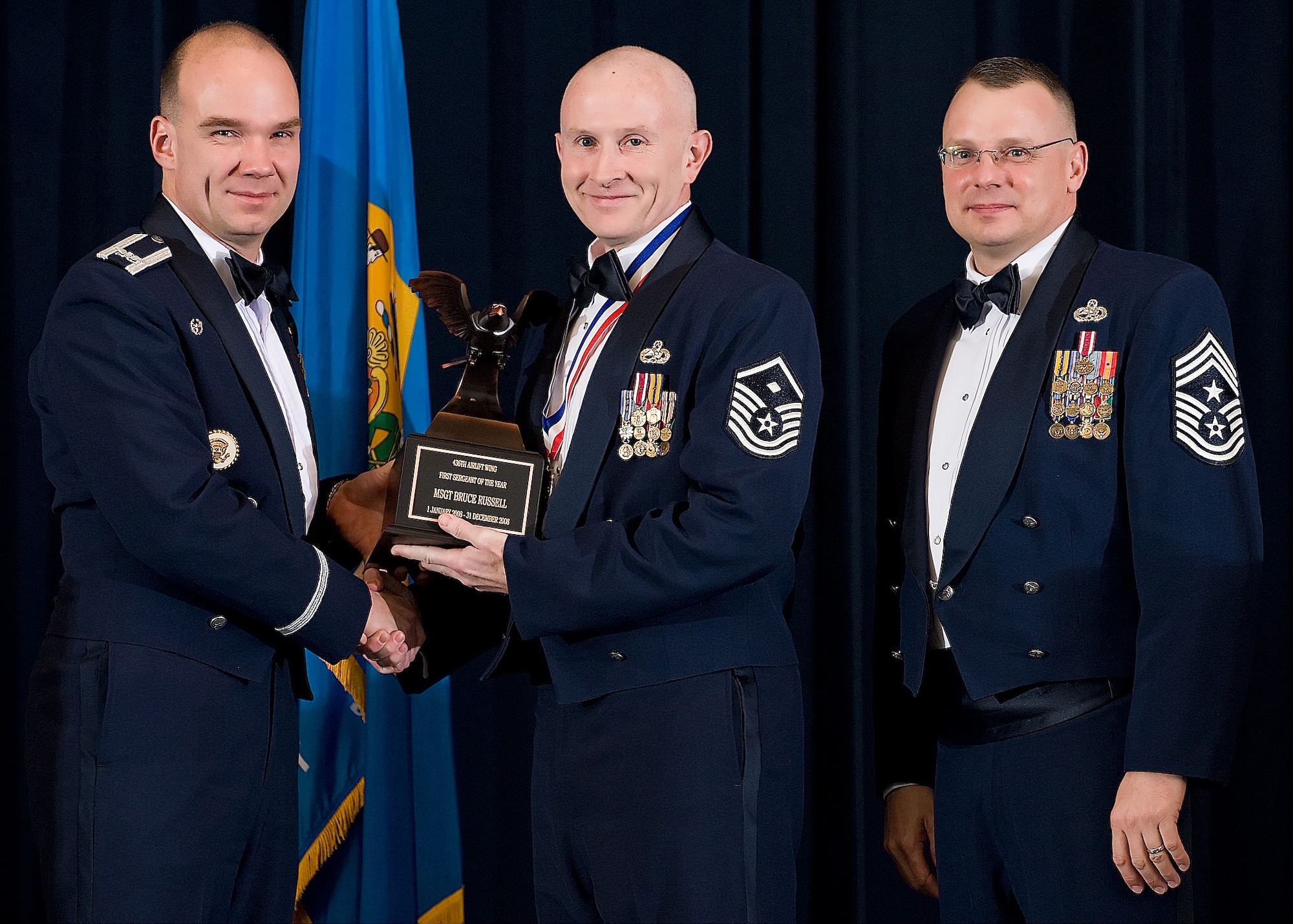 (Left) Col. Manson Morris, 436th Airlift Wing commander, and Chief Master Sgt. John Wood, 436th AW command chief, present Master Sgt. Bruce Russell, 436th Maintenance Squadron, with the award for First Sergeant of the Year during the Annual Awards ceremony Feb. 13.  (U.S. Air Force photo/Roland Balik)