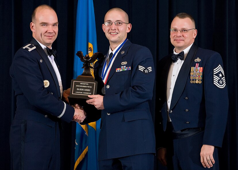 (Left) Col. Manson Morris, 436th Airlift Wing commander, and Chief Master Sgt. John Wood, 436th AW command chief, present Senior Airman Bruno Carreiro, 436th Aerial Port Squadron, with the award for Honor Guard Member of the Year during the Annual Awards ceremony Feb. 13.  (U.S. Air Force photo/Roland Balik)