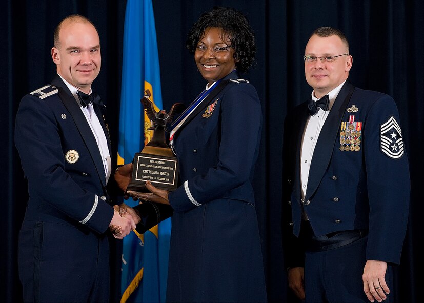 (Left) Col. Manson Morris, 436th Airlift Wing commander, and Chief Master Sgt. John Wood, 436th AW command chief, present Capt. Redahlia Person, 436th Aircraft Maintenance Squadron, with the award for Senior Company Grade Officer of the Year during the Annual Awards ceremony Feb. 13.  (U.S. Air Force photo/Roland Balik)