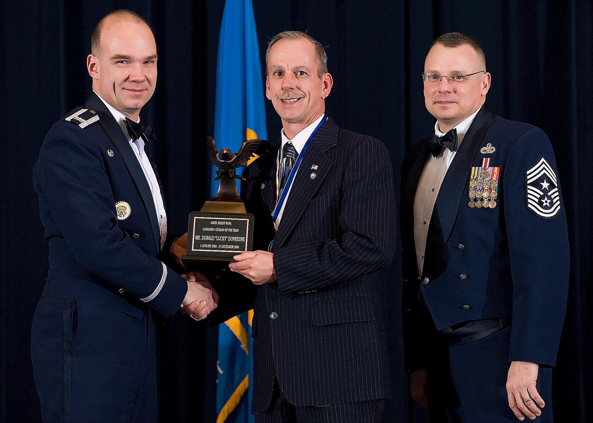 (Left) Col. Manson Morris, 436th Airlift Wing commander, and Chief Master Sgt. John Wood, 436th AW command chief, present Donald ?Lucky? DuFresne, 436th AW protocol office, with the award for Category I Civilian of the Year during the Annual Awards ceremony Feb. 13.  (U.S. Air Force photo/Roland Balik)