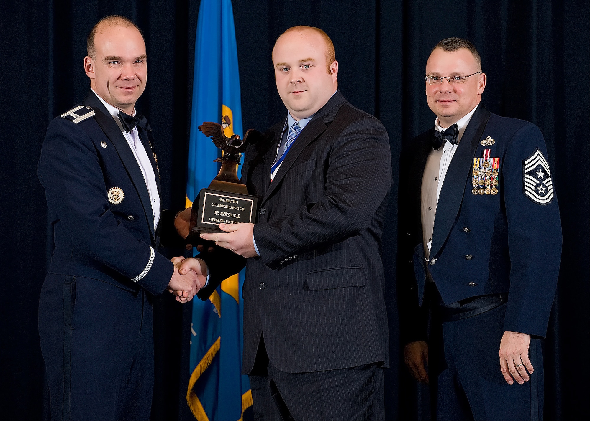(Left) Col. Manson Morris, 436th Airlift Wing commander, and Chief Master Sgt. John Wood, 436th AW command chief, present Andrew Dale, 436th Logistics Readiness Squadron, with the award for Category II Civilian of the Year during the Annual Awards ceremony Feb. 13.  (U.S. Air Force photo/Roland Balik)