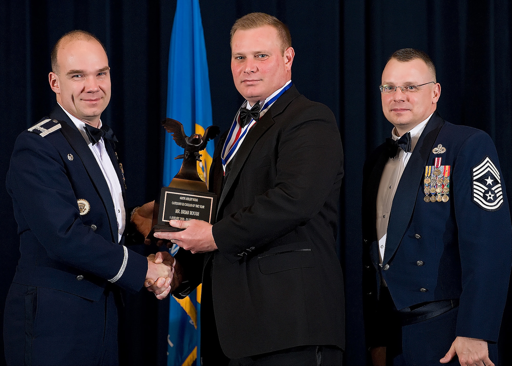 (Left) Col. Manson Morris, 436th Airlift Wing commander, and Chief Master Sgt. John Wood, 436th AW command chief, present Brian Roush, 436th Force Support Squadron, with the award for Category III Civilian of the Year during the Annual Awards ceremony Feb. 13.  (U.S. Air Force photo/Roland Balik)