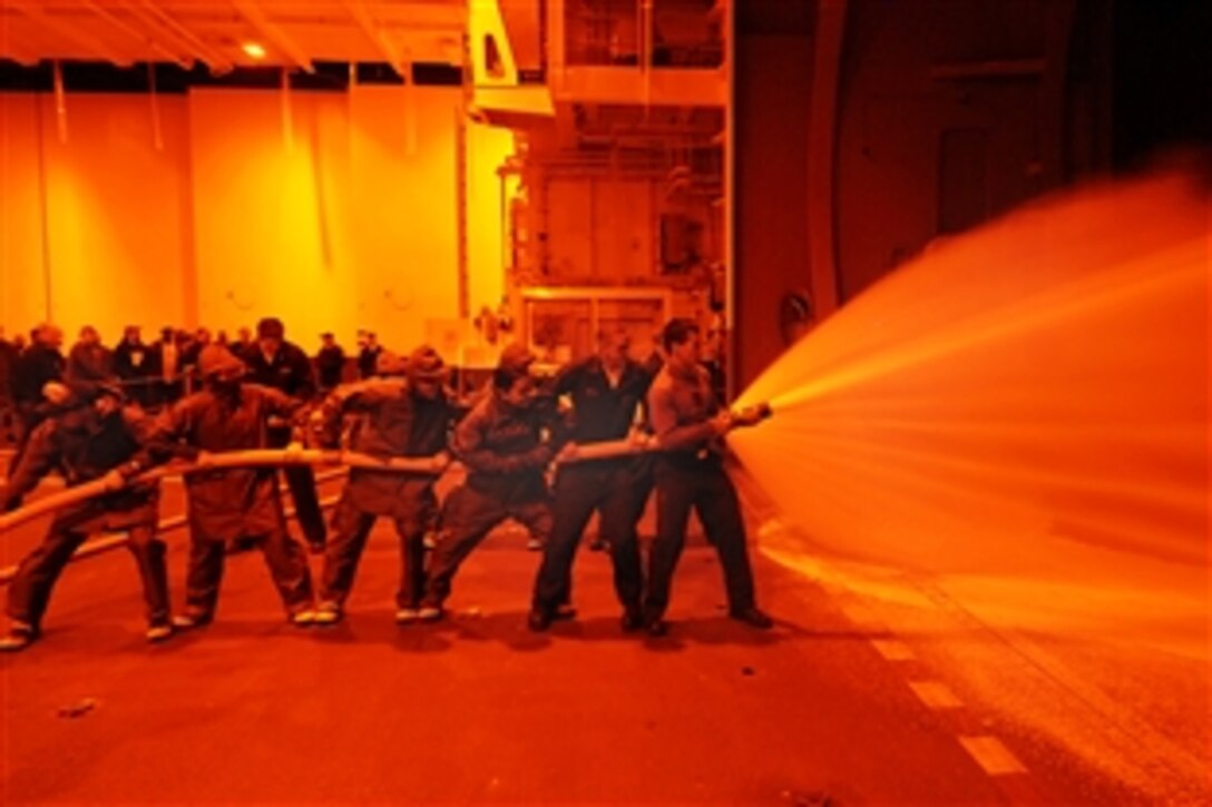 U.S. Navy sailors test an aqueous foam hose in the hangar bay of the Navy's newest aircraft carrier USS George H.W. Bush in the Atlantic Ocean, Feb. 15, 2009.