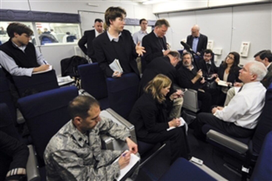 Defense Secretary Robert M. Gates, right, listens to questions from members of the press during a press availability aboard the National Airborne Operations Center aircraft before departing for Krakow Poland, Feb. 18, 2009. Gates was headed to Poland to meet with NATO defense ministers.