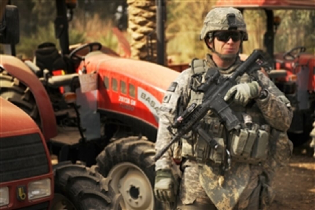U.S. Army Staff Sgt. Jason McCullough provides security while his fellow soldiers survey a tractor storage facility in Diwaniyah, Iraq, Feb. 12, 2009. McCoullough is assigned to the 4th Infantry Division's 2nd Brigade Combat Team.