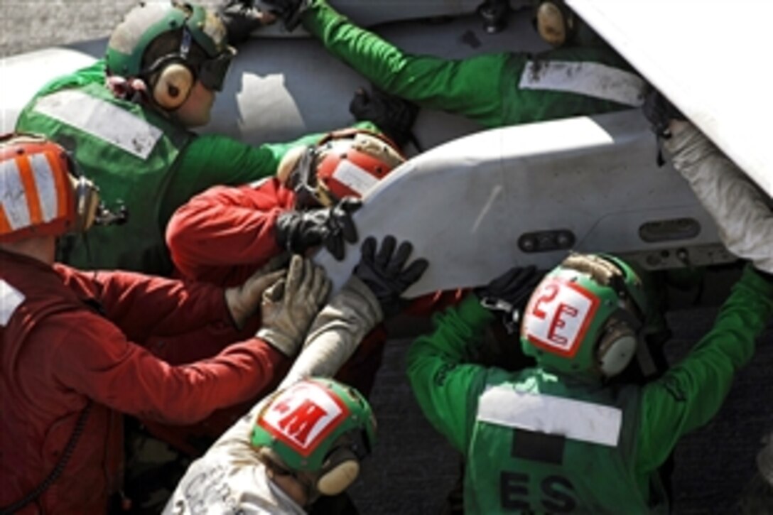 U.S. Navy flight deck personnel push an F/A-18C from Marine Strike Fighter Squadron 323 during flight operations aboard the aircraft carrier USS John C. Stennis in the Pacific Ocean, Feb. 15, 20009.