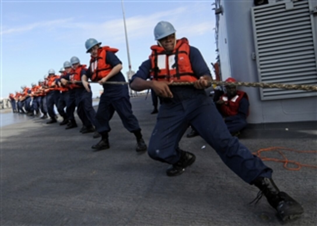 U.S. Navy Seaman Darrell Moore (right), assigned to the deck department aboard the amphibious command ship USS Blue Ridge (LCC 19), and other sailors pull on a messenger line during an underway replenishment with the Military Sealift Command supply ship USNS Pecos (T-AO 197) while in the Pacific Ocean on Feb. 17, 2009.  