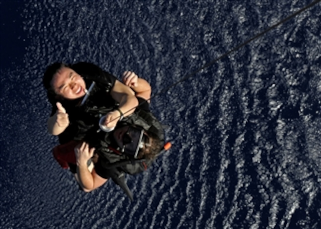 U.S. Navy Petty Officer 2nd Class Kelvin Y. Chen (left) and Petty Officer 2nd Class Kevin M. Abney, both search and rescue swimmers assigned to the USS Blue Ridge (LCC 19), get pulled out of the water by an SH-60F Seahawk helicopter during a training exercise in the Pacific Ocean on Feb. 18, 2009.  