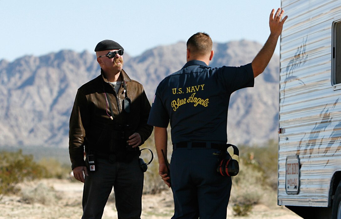 Mythbusters co-host Jamie Hyneman listens to Petty Officer 3rd Class Peter Carnicello, of the Blue Angels public affairs office, as he explains the effects of a sonic boom on a trailer Feb. 19, 2009, on the Barry M. Goldwater Range east of the Marine Corps Air Station in Yuma, Ariz. The Blue Angels invited the popular Discovery Channel program to test the myth that a sonic boom, caused when aircraft travel faster than the speed of sound, will break glass. The episode, filmed Febuary 2009, is scheduled to air June 10, 2009, at 9 p.m. EST on The Discovery Channel.