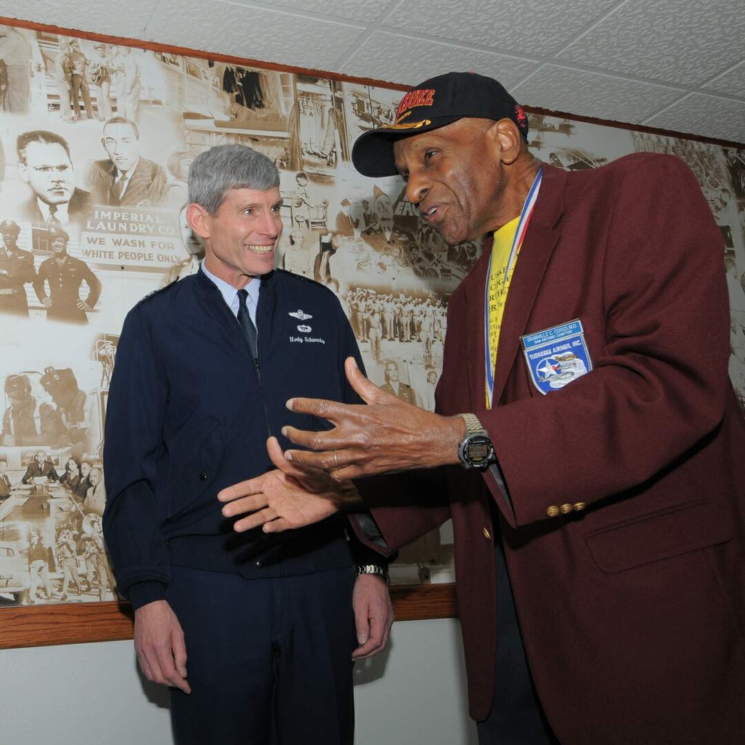 Air Force Chief of Staff Gen. Norton Schwartz visits with Dr. Granville Coggs Feb. 19 in front of the Tuskegee Airmen mural in the main corridor of the 99th Flying Training Squadron at Randolph Air Force Base, Texas. Dr. Coggs is a Tuskegee Airman who trained at Tuskegee Institute in the 1940s. The 99th FTS traces its roots back to the 99th Fighter Squadron, which was the first all-black unit in the Army Air Corps when it activated in May 1942. (U.S. Air Force photo/Melissa Peterson)