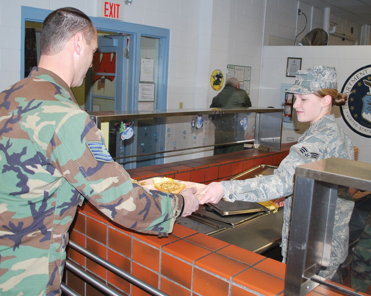 Senior Airman Kelsi Larsen serves Tech. Sgt. Patrick Marino breakfast during annual training at Volk Field, Wis. Jan. 9th.  Members of the 114th Security Forces Squadron and the 114th Services Flight worked together to complete two weeks annual training in the wintery environment.
