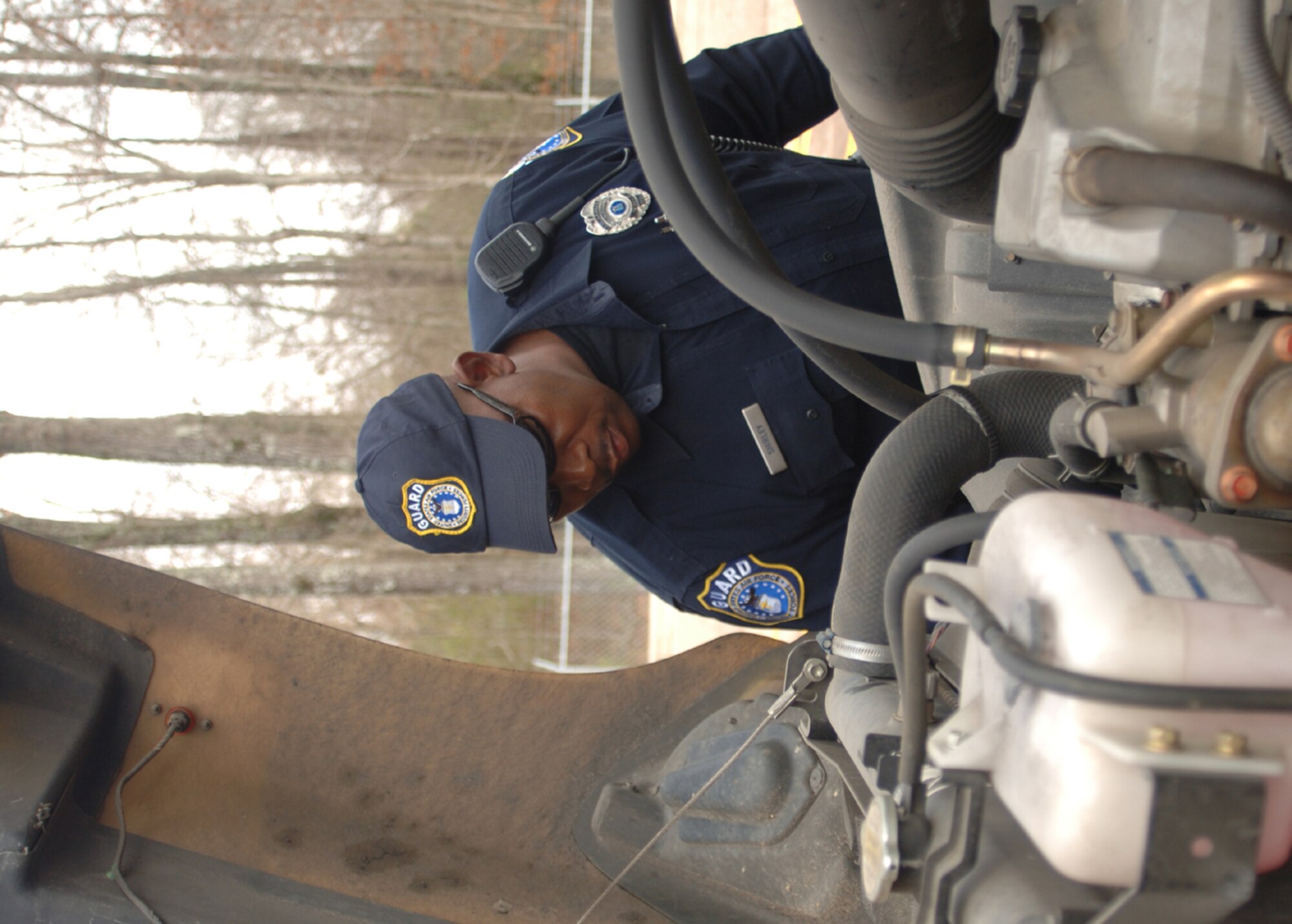 Police Officer Ernie Shirley, a Department of Defense civilian assigned to the 14th Security Forces Squadron, checks an incoming commercial driver’s engine Feb. 18 at the Columbus Air Force Base vehicle inspection area. (U.S. Air Force photo/Senior Airman Jacob Corbin) 