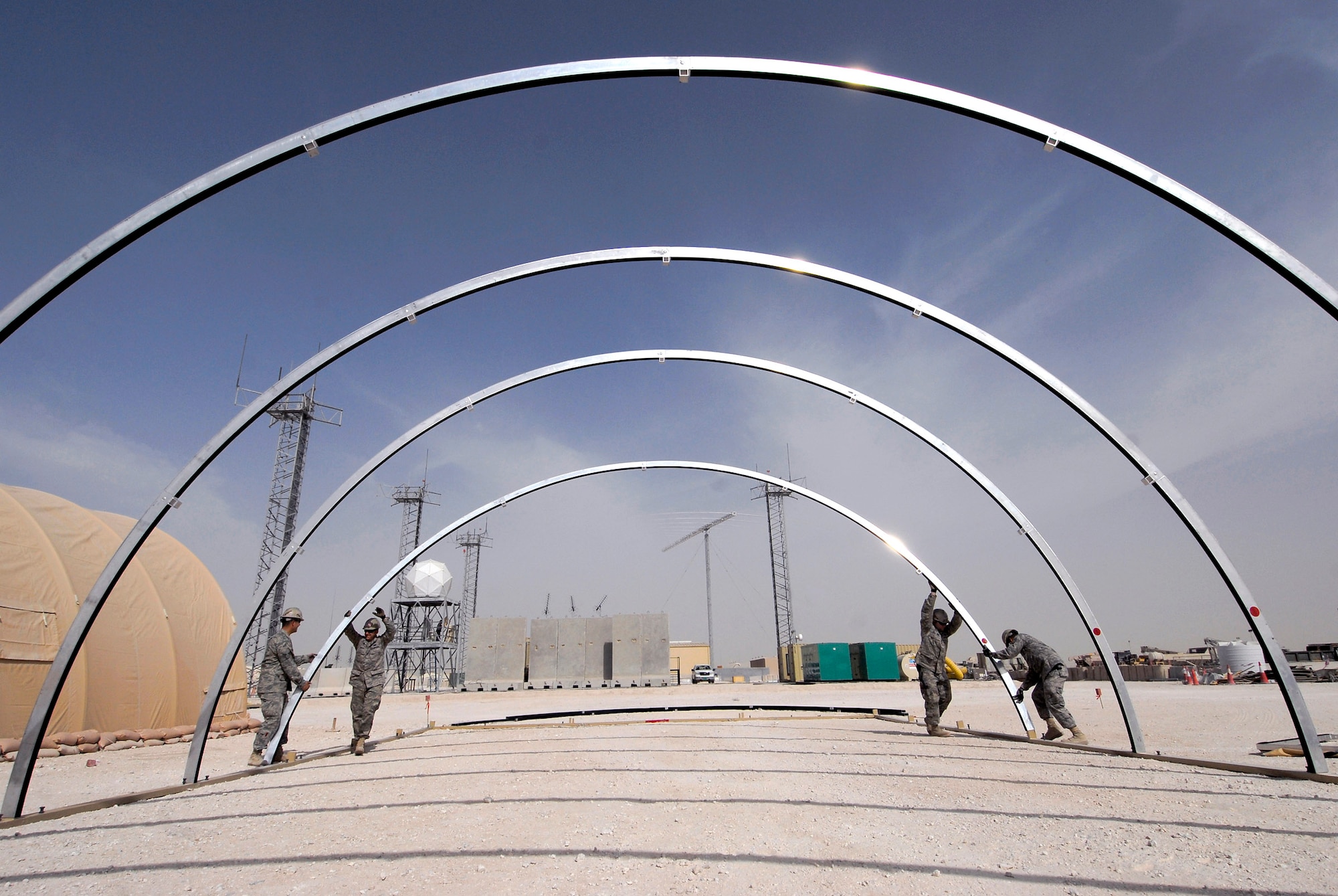 Structures team members from the 379th Expeditionary Civil Engineer Squadron set the arches Feb. 17 for a California Medium Shelter System to house Airmen at an air base in Southwest Asia. (U.S. Air Force photo/Airman 1st Class Andrew Satran) 