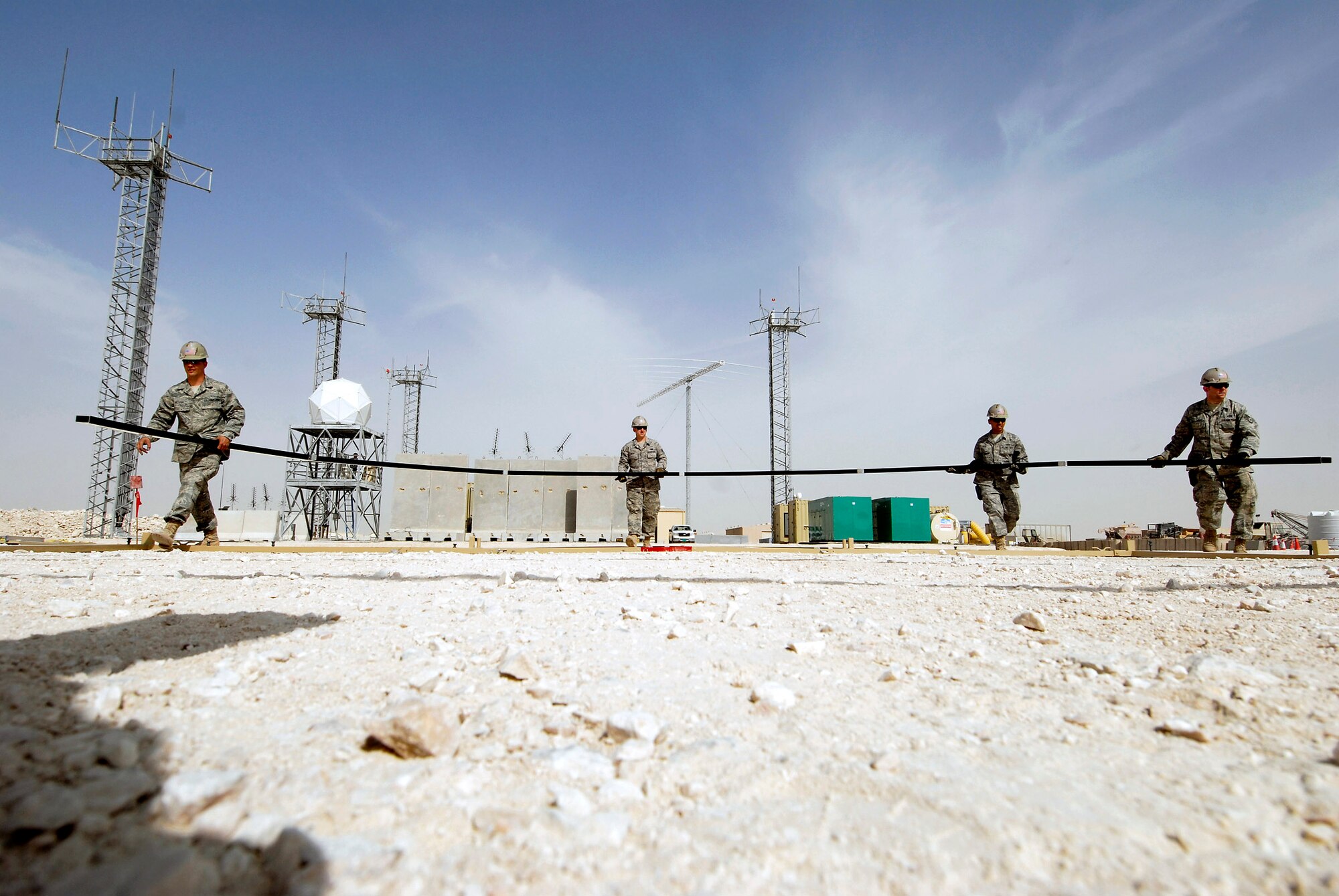 Structures team members from the 379th Expeditionary Civil Engineer Squadron move the first arch into position Feb. 17 to build a California Medium Shelter System to house Airmen at an air base in Southwest Asia. (U.S. Air Force photo/Airman 1st Class Andrew Satran)