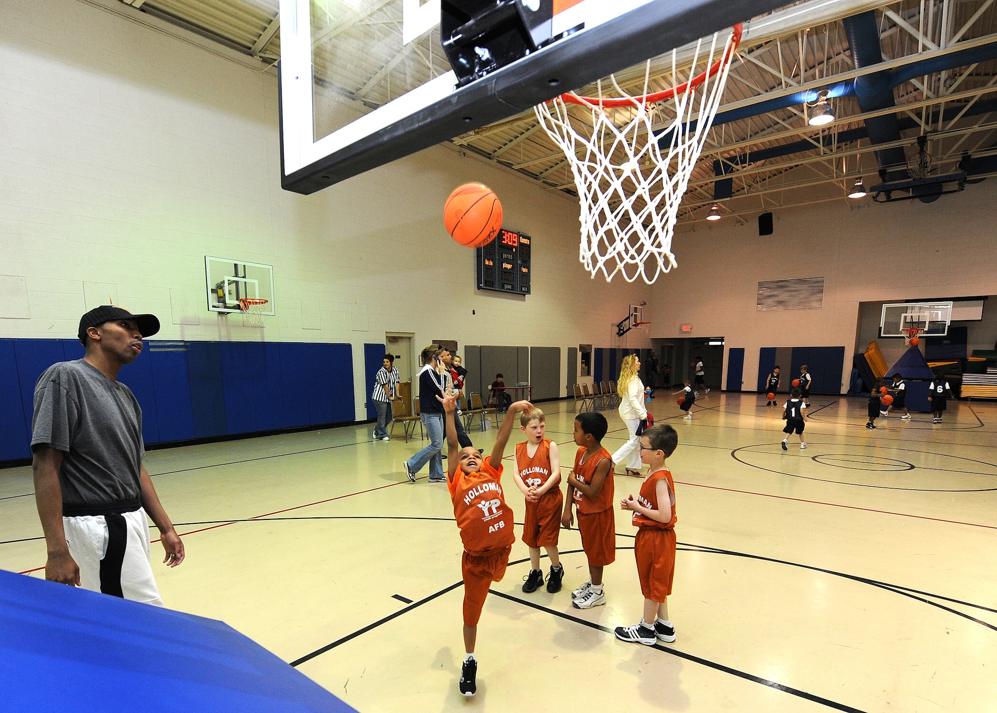 Staff Sgt. Mark Daniels, 4th Space Control Squadron, coaches children at the Youth and Teens Center before a basketball game at Holloman Air Force Base, N.M., Feb. 12. The Holloman Youth and Teen Center host several seasonal sports programs for youths such as soccer, tee ball, baseball and basketball. (U.S. Air Force photo/Senior Airman Michael Means)