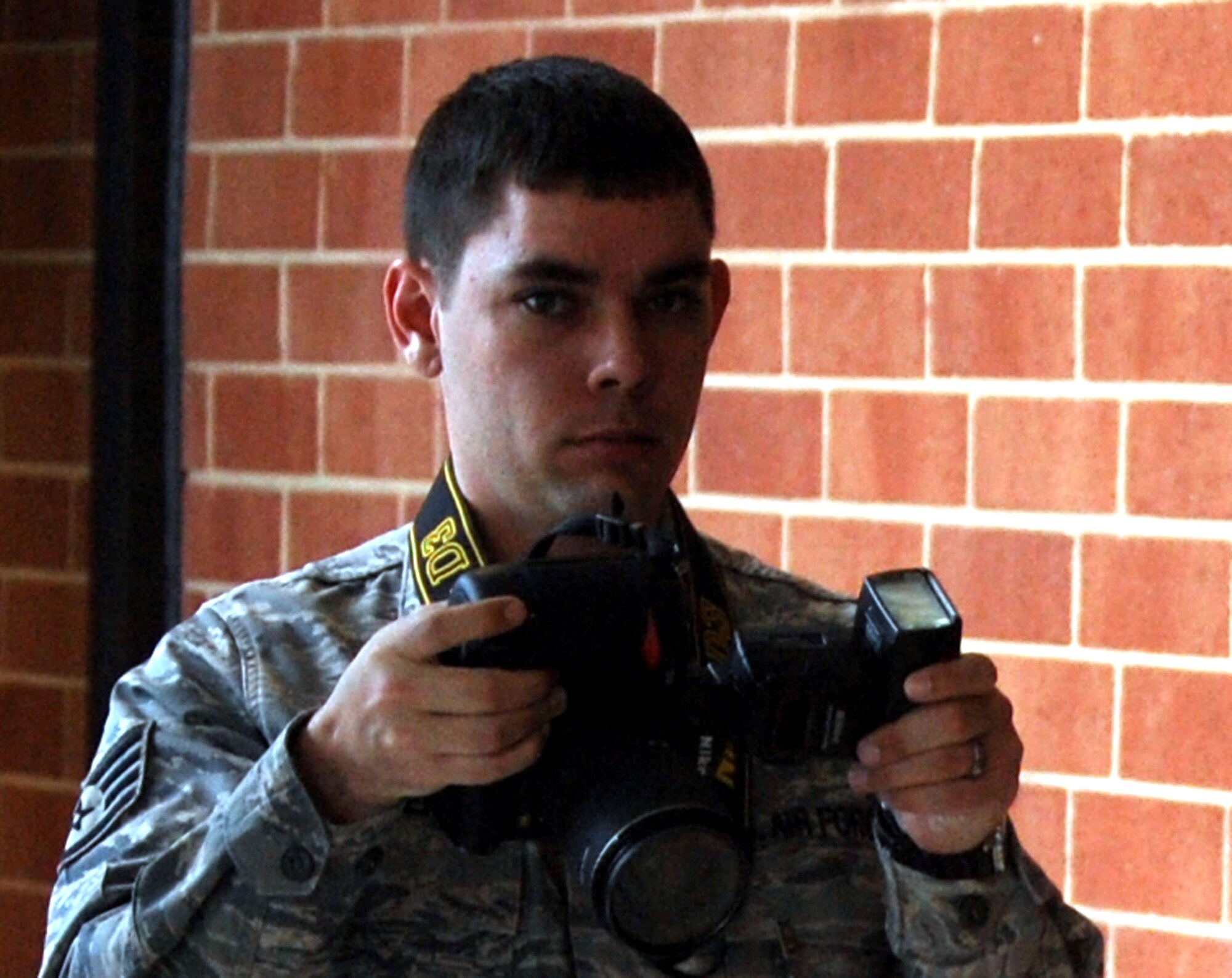 Staff Sgt. Nathan G. Bevier, NCO in charge of public affairs photography for the U.S. Air Force Expeditionary Center Public Affairs Office, takes photos during an event on Feb. 10, 2009, in the USAF EC on Fort Dix, N.J.  Sergeant Bevier's the only photographer assigned to the center and is also Air Mobility Command's runner-up winner for Photographer of the Year for 2008.  (U.S. Air Force Photo/Tech. Sgt. Scott T. Sturkol)