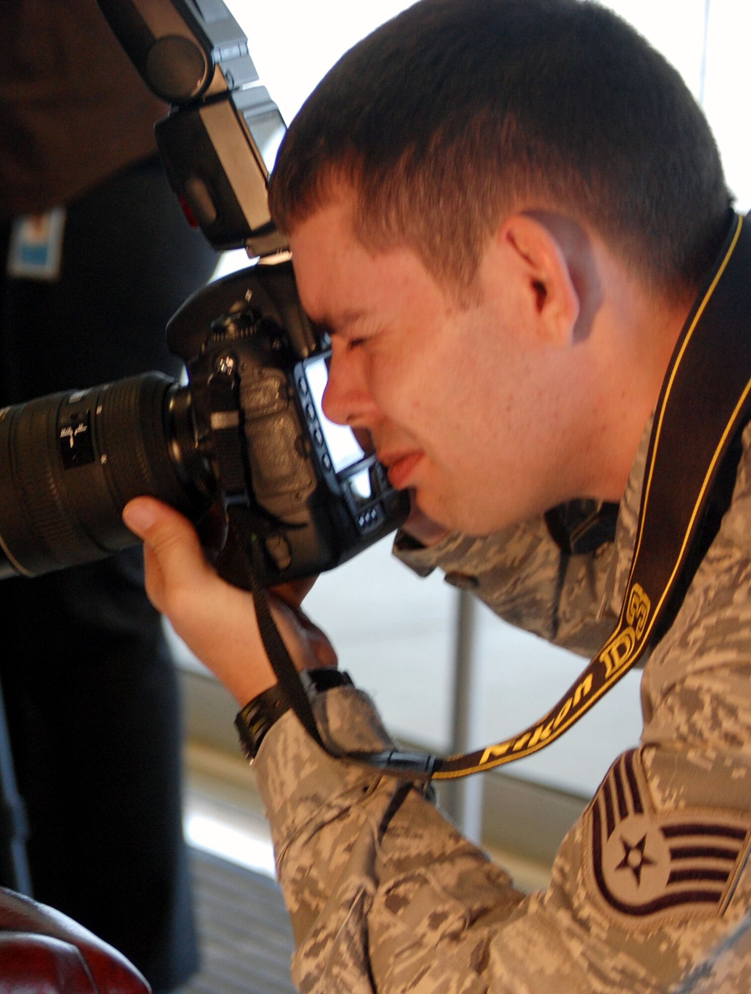 Staff Sgt. Nathan G. Bevier, NCO in charge of public affairs photography for the U.S. Air Force Expeditionary Center Public Affairs Office, takes photos during an event on Feb. 10, 2009, in the USAF EC on Fort Dix, N.J.  Sergeant Bevier's the only photographer assigned to the center and is also Air Mobility Command's runner-up winner for Photographer of the Year for 2008.  (U.S. Air Force Photo/Tech. Sgt. Scott T. Sturkol)