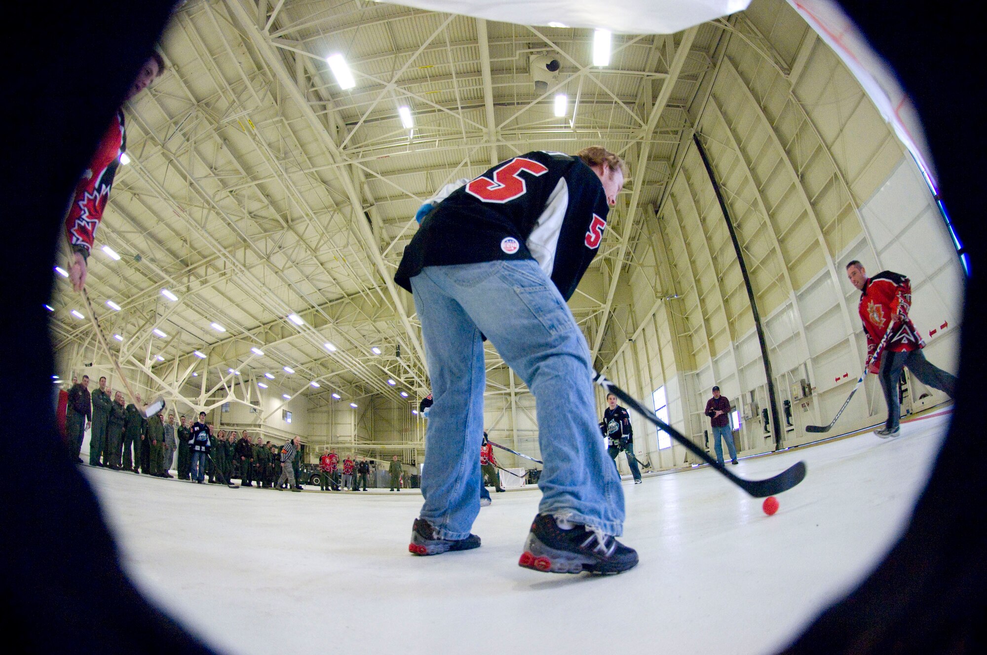 ELMENDORF AIR FORCE BASE, Alaska -- Alaska Aces hockey player Ryan Turek keeps the puck out of the hands of 962nd Airborne Air Control Squadron players during a game Feb. 19, 2009. Officials from the 962nd AACS invited the Aces players to tour the 962nd AACS facility, the AWACS hangar and an E-3 Sentry before the friendly competition. Both Canadian and U.S. Air Force members of the 962nd made up squadron team. (U.S. Air Force photo/Senior Airman Jonathan Steffen)