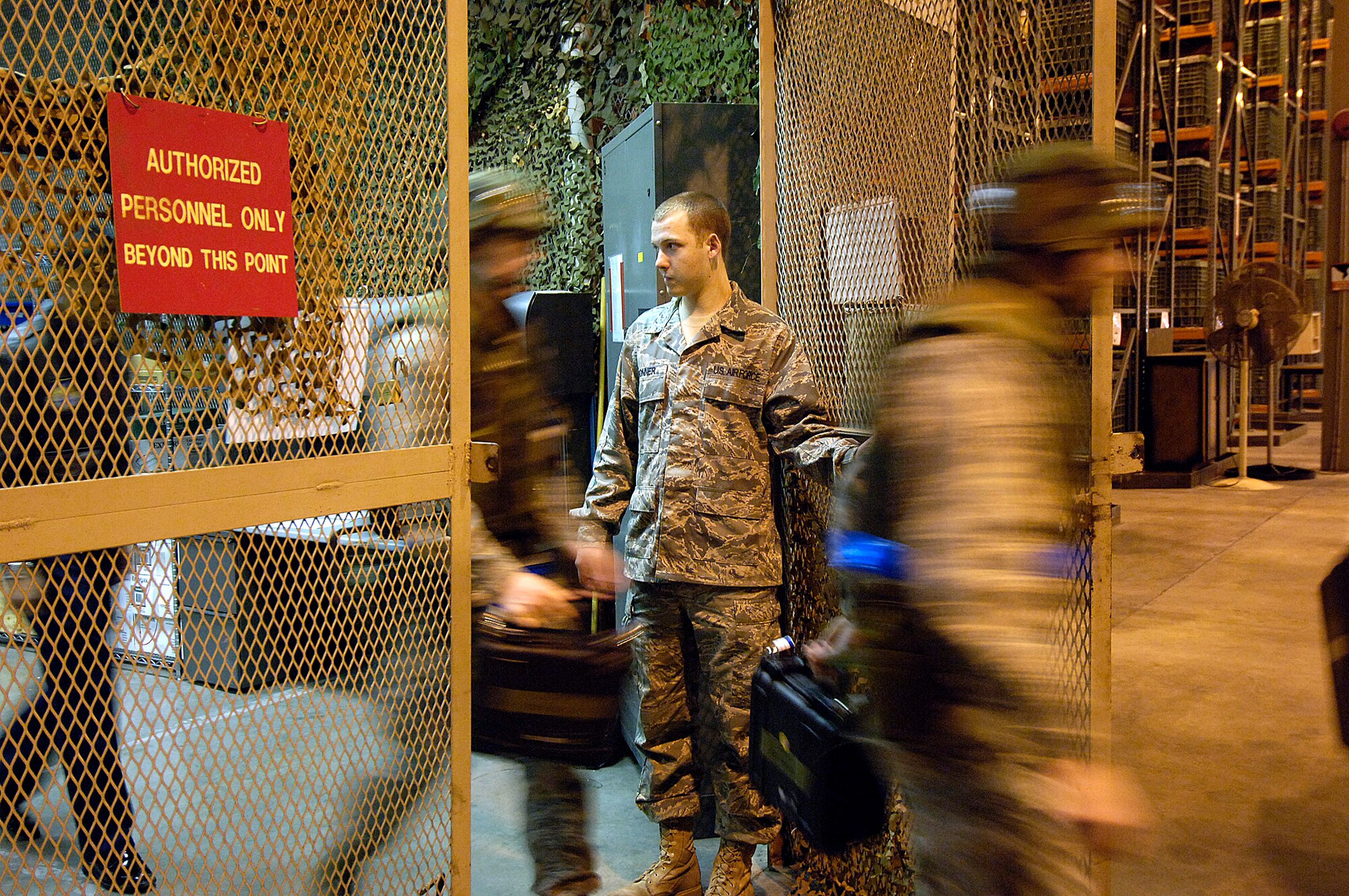 Senior Airman Casey Bonner stands guard at the door of the 72nd Logistics Readiness Squadron’s weapons vault as Airmen stream out after getting weapons during the recent War Wagon 09-02 exercise.(Air Force photo/Margo Wright)