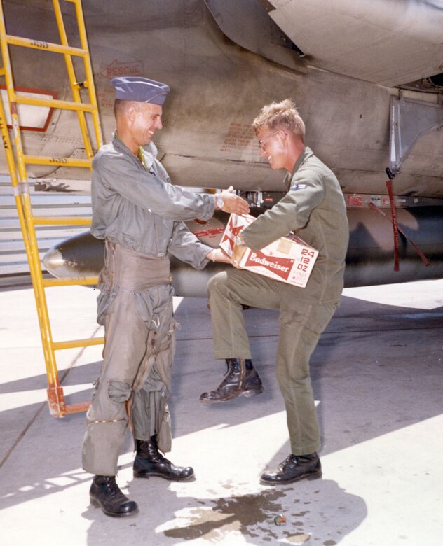 Ground crews played an essential role in completing a 100 mission tour. Here Maj. Robert Krone, 469th TFS commander, gives his crew chief a gift and a heartfelt handshake after completing his 100 missions on June 3, 1966. (U.S. Air Force photo)