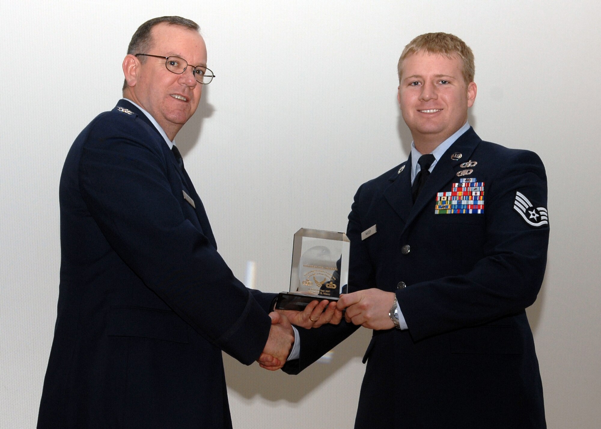 Spangdahlem, Air Base -- Staff Sgt. David Masey, 606th Air Control Squadron, is congratulated by Col. Patrick McCrea, 52nd Operations Group commander, for being named the 2007 Headquarters U.S. Air Force Outstanding Aerospace Control and Warning Systems Operator of the Year Award, NCO category Feb. 13, 2009.  Sergeant Masey earned the award for his outstanding work at home station and while he was deployed.  (U.S. Air Force Photo by Senior Airman Allen Pollard)