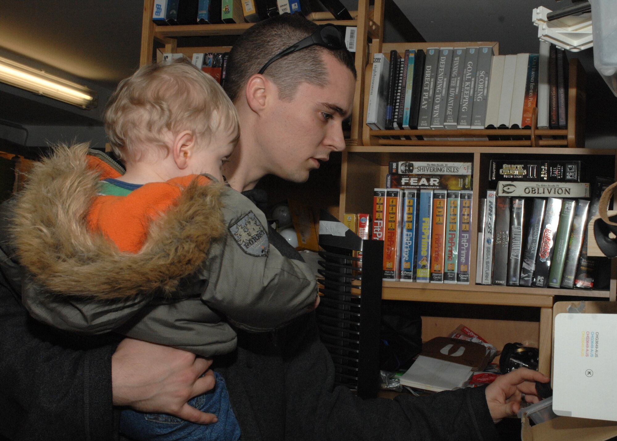 SPANGDAHLEM AIR BASE, Germany -- Airman 1st Class Matthew Neeves, 52nd Air Maintenance Squadron, and his son, “Little Matthew,” look through various 220-voltage electronics at the Airman’s Attic Feb. 19, 2009.  The Airman’s Attic provides free items to all Airmen, no matter what rank. The Airman’s Attic is open 11 a.m. to 3 p.m. Monday through Wednesday or 11 a.m. to 4 p.m. Thursday. It is located in the basement of building 418. (U.S. Air Force photo by Senior Airman Jenifer H. Calhoun)