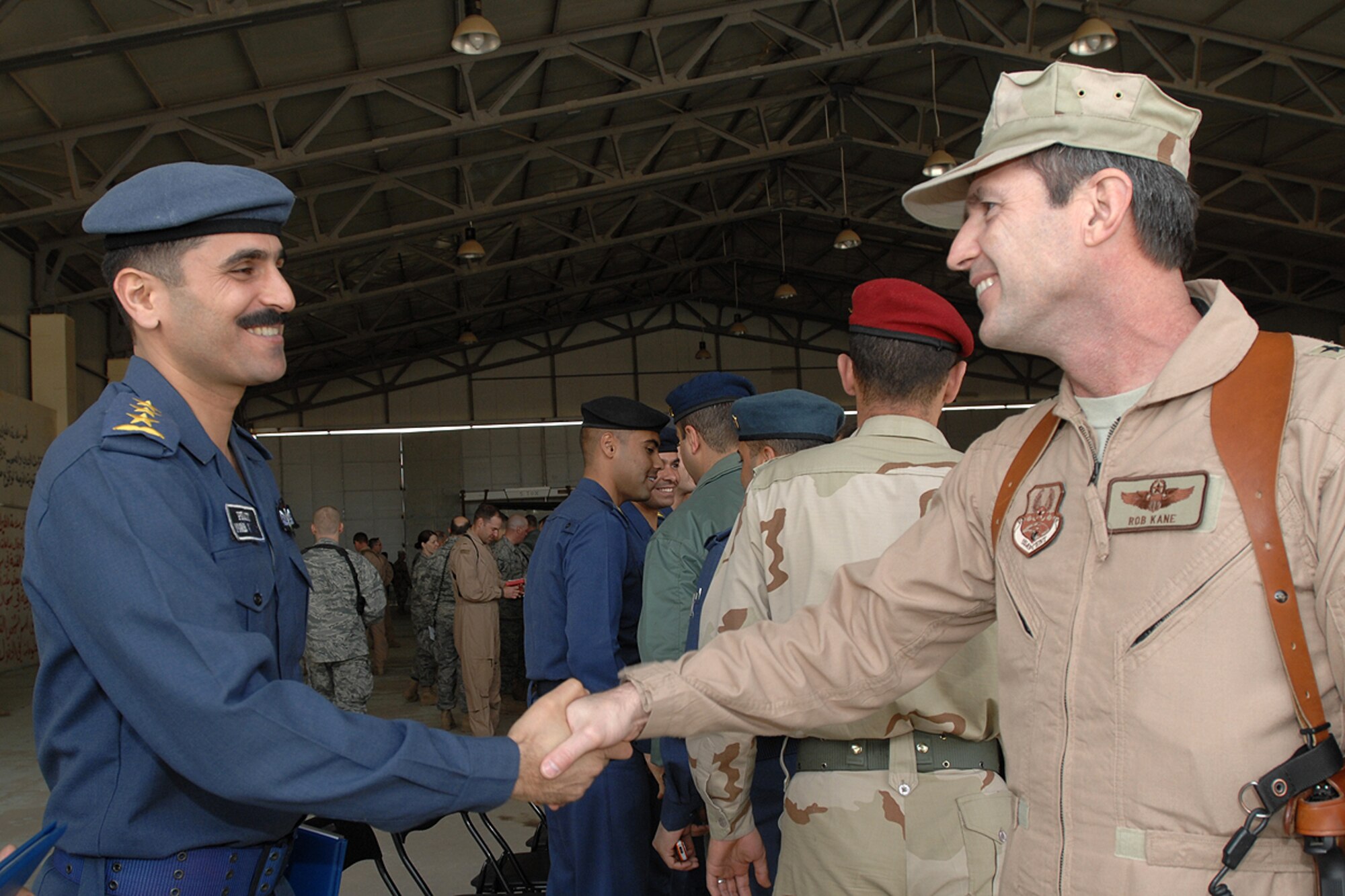 KIRKUK REGIONAL AIR BASE, Iraq – Brig. Gen. Robert Kane, Coalition Air Force Transition Team commanding general, congratulates Capt. Yaarub Abdul Waheh Rasheed, Iraqi Air Force instructor pilot, during the Iraqi Air Force pilot graduation ceremony here Feb. 19. There were fourteen pilots and instructor pilots honored during the ceremony.  (U.S. Air Force photo / Senior Airman Eunique Stevens)