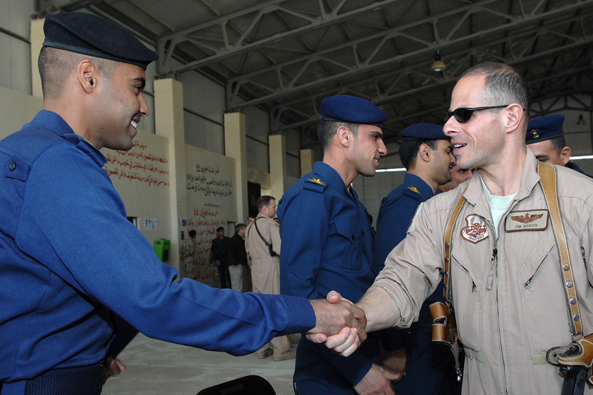 KIRKUK REGIONAL AIR BASE, Iraq – Maj. James Booth, 52nd Expeditionary Flying Training Squadron instructor pilot, congratulates an Iraqi pilot during the Iraqi Air Force Flying Training Wing’s graduation ceremony here Feb. 19. 52nd EFTS instructor pilots assigned here provide fixed-wing flight training to the Iraqi students in the Cessna 172. (U.S. Air Force photo / Senior Airman Eunique Stevens)