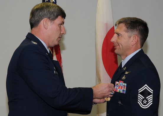 KADENA AIR BASE, Japan -- Col. David Mullins, the 353rd Special Operations Group Commander, pins an Air Medal on Senior Master Sgt. Thomas Rich, 31st Rescue Squadron, here Feb. 19 for his efforts during a September 2008 rescue mission on a ship in the Pacific Ocean.  Sergeant Rich was one of five pararescuemen who jumped from the MC-130H Combat Talon II to provide more than 32 continuous hours of medical care to injured sailors aboard the Occam's Razor. The ship was en route to Chile when two crew members were injured in a crane accident while sailing about 1,200 miles east of Okinawa and 500 miles north of Guam, and required immediate medical attention. (U.S. photo by Tech. Sgt. Aaron Cram)
