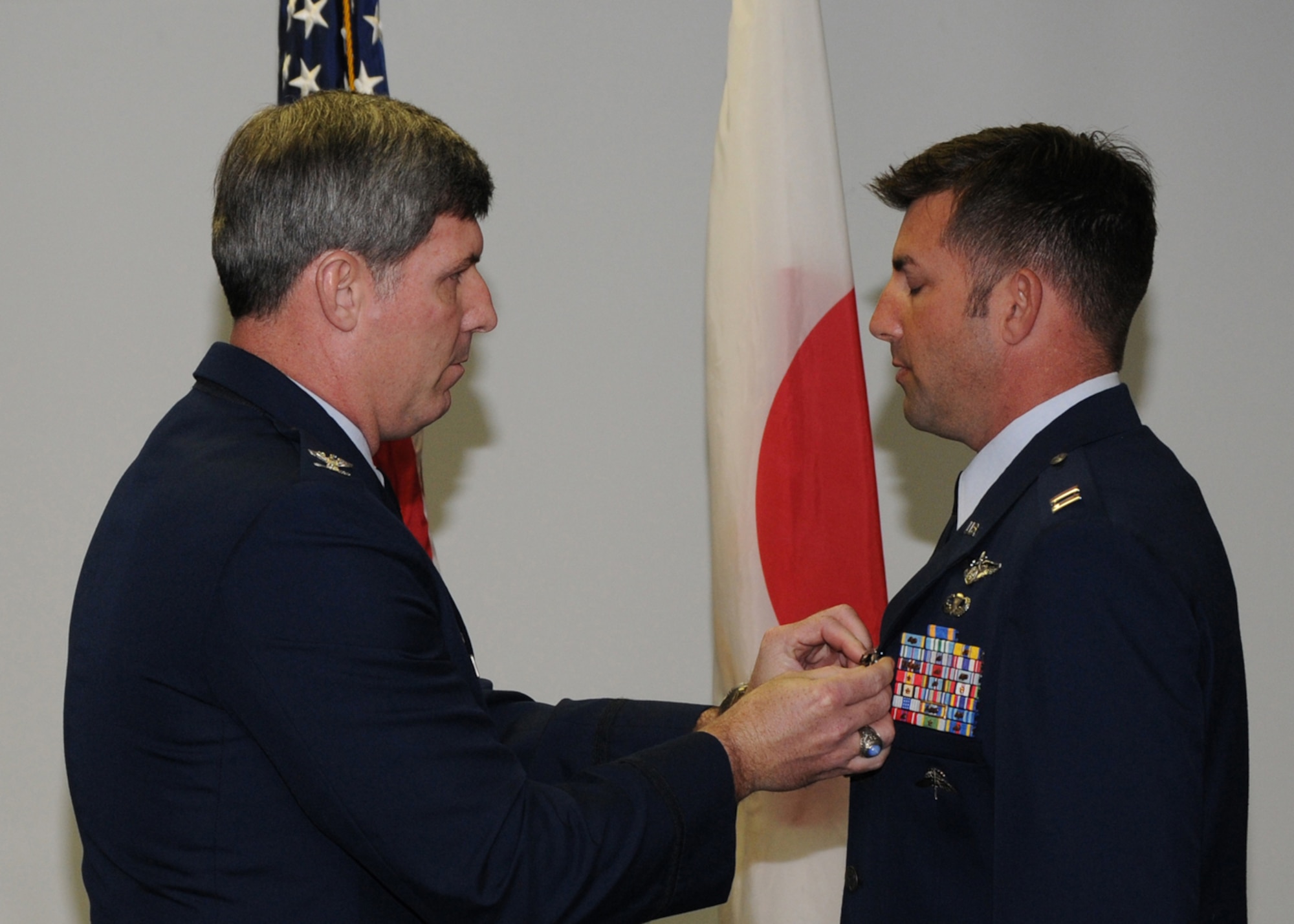 KADENA AIR BASE, Japan -- Col. David Mullins, the 353rd Special Operations Group Commander, pins an Air Force Commendation Medal on Capt. Jonathan Harmon, 31st Rescue Squadron, here Feb. 19 for his efforts during a September 2008 rescue mission on a ship in the Pacific Ocean.  Capt. Harmon was one of two key planners who coordinated all mission-specific requirements to enable the combined rescue team and provided command and control by making time-sensitive decisions throughout the operation. (U.S. photo by Tech. Sgt. Aaron Cram)