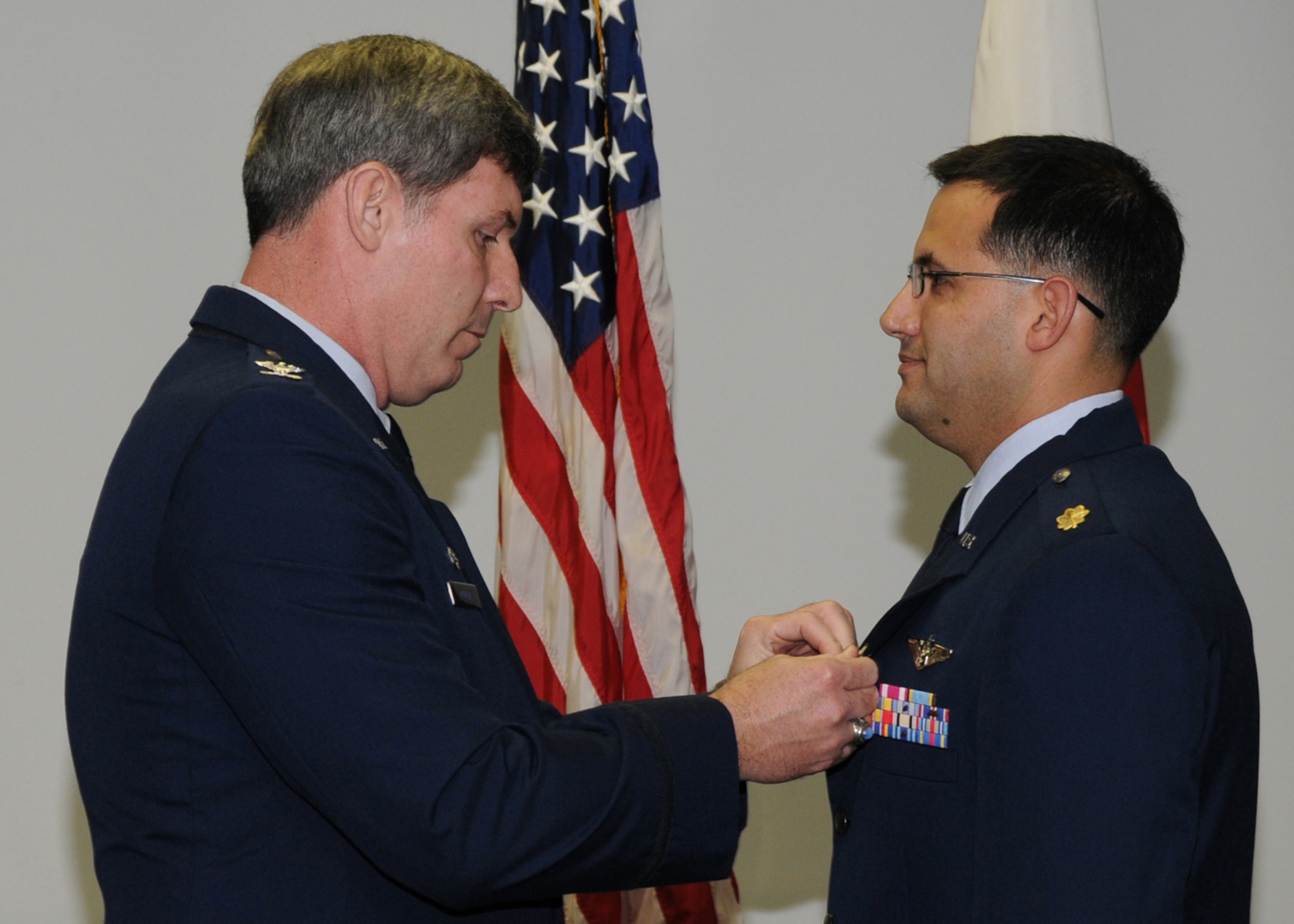 KADENA AIR BASE, Japan -- Col. David Mullins, the 353rd Special Operations Group Commander, pins an Air Force Achievement Medal on Maj. Scott Cummis, 353rd Operations Support Squadron, here Feb. 19 for his efforts during a September 2008 rescue mission on a ship in the Pacific Ocean. Maj. Cummis and two other doctors provided key medical advice to the commander for pre-mission risk assessment and medical oversight from the group's Special Operations Center to the pararescuemen onboard the Occam's Razor for more than 32 hours. (U.S. photo by Tech. Sgt. Aaron Cram)