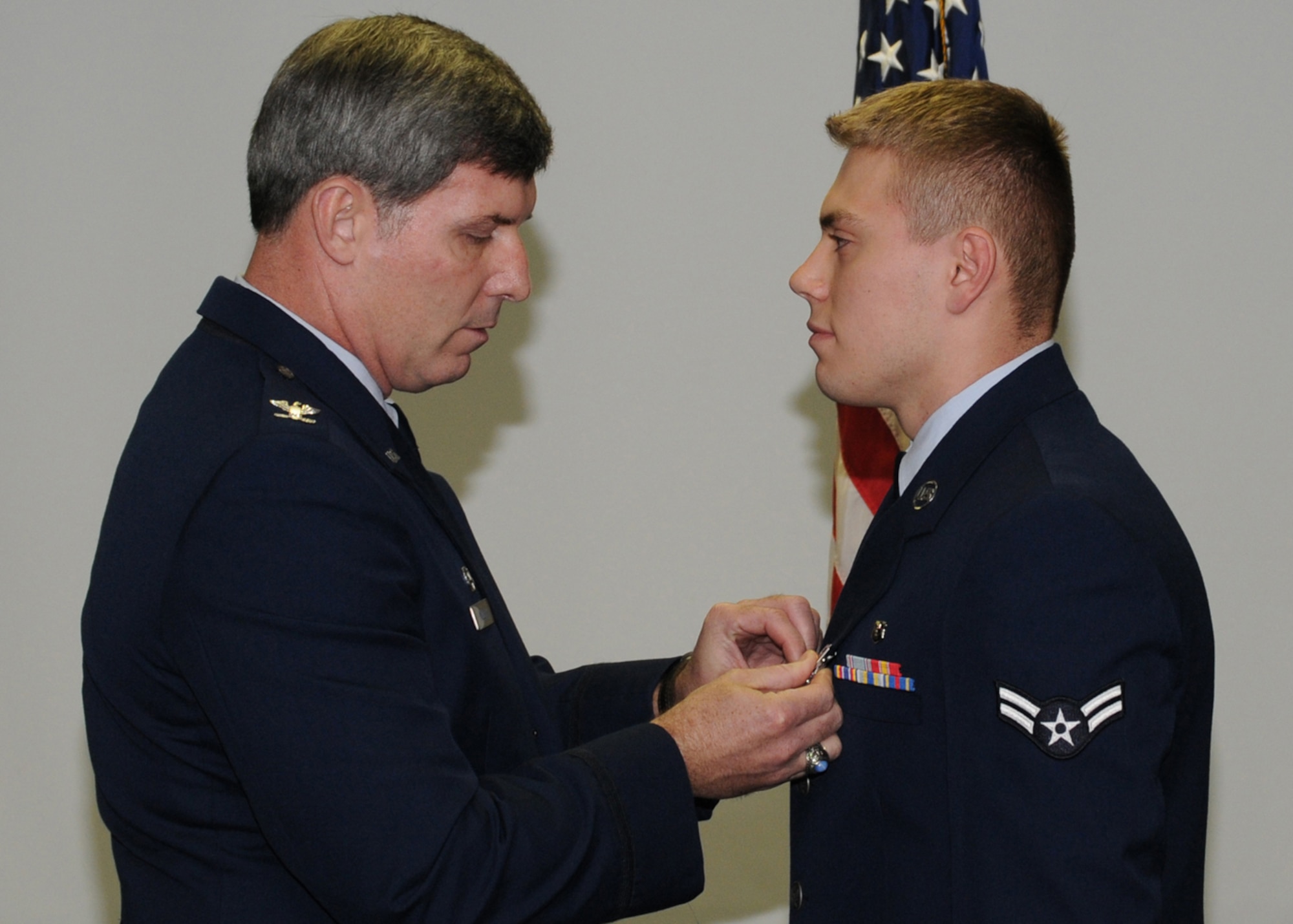 KADENA AIR BASE, Japan -- Col. David Mullins, the 353rd Special Operations Group Commander, pins an Air Force Achievement Medal on Airman 1st Class Daniel Shimanski, 18th Aerospace Medical Squadron, here Feb. 19 for his efforts during a September 2008 rescue mission on a ship in the Pacific Ocean. Airman Shimanski's proficiency in the Russian language was critical to flawlessly relaying the intricacies of the rescue operations to the Ukrainian crew. His ability allowed critical information of the ship's medical capabilities, boarding options, direction, and speed to be passed to the rescue crew on the MC-130H. (U.S. photo by Tech. Sgt. Aaron Cram)