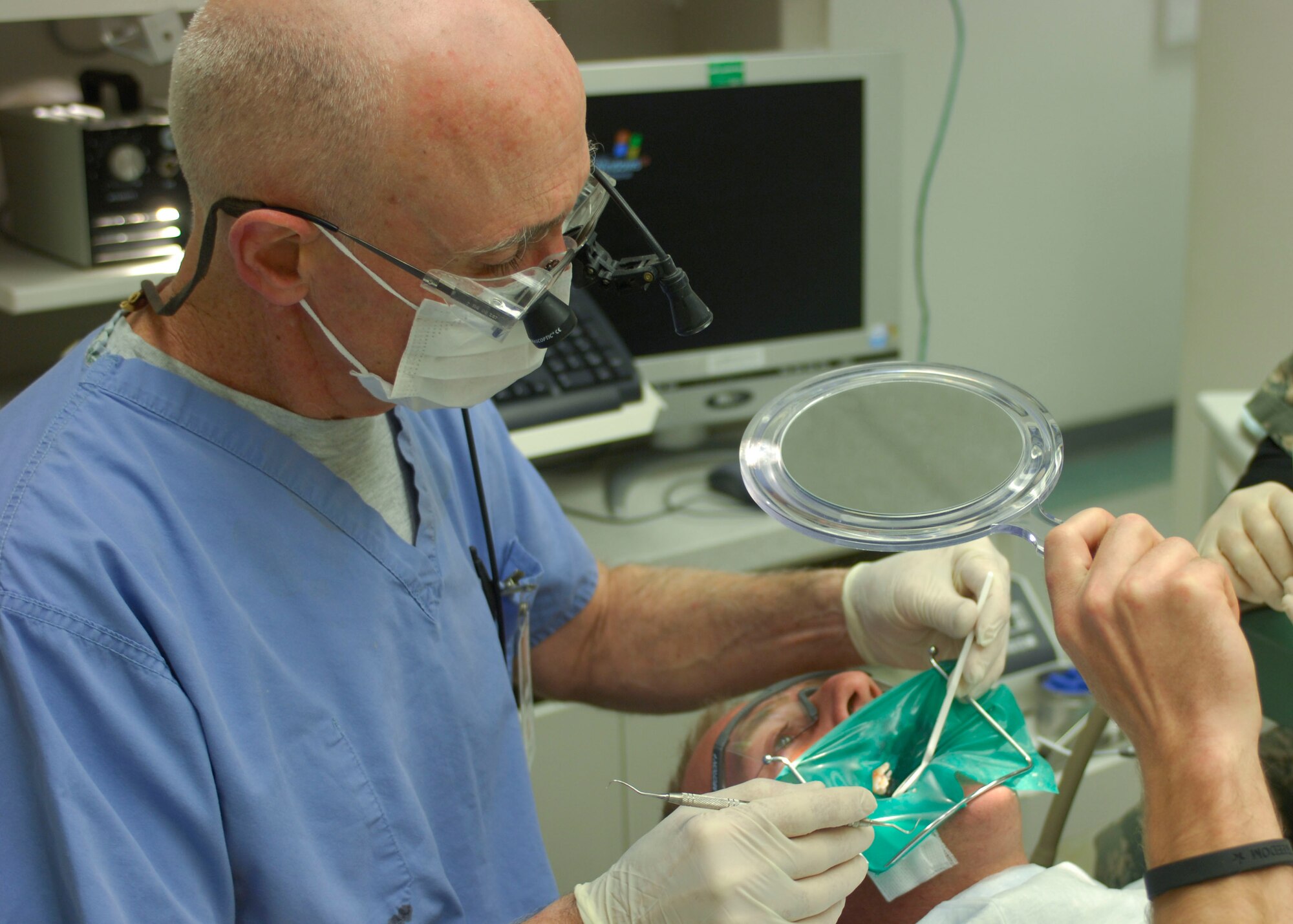 Col. Dennis Hayes, 455th Medical Group officer-in-charge of dental, performs a silver filling on Sgt. Jason Stainger, New Zealand Provincial Reconstruction Team, at Bagram Air Field, Afghanistan, Feb. 16. Emergency dental care is open six days a week, 24 hours a day. Colonel Hayes is deployed from the 375th Dental Squadron, Scott AFB, Ill.(U.S Air Force photo/ Senior Airman Erik Cardenas)(Released)  