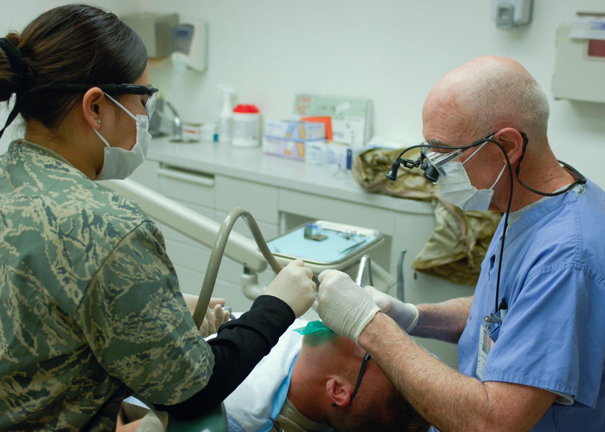 Senior Airman Chelsie Smith, 455th Medical Group dental technician, assists Col. Dennis Hayes, 455th Medical Group, officer-in-charge of dental, with a silver filling at Bagram Air Field, Afghanistan, Feb. 16. The dental clinic is joint serviced with the Army and sees an average of 650 patients per month. Airman Smith is deployed from the 60th Dental Squadron, Travis Air Force Base, Calif. Colonel Hayes is deployed from the 375th Dental Squadron, Scott AFB, Ill. (U.S. Air Force photo/ Senior Airman Erik Cardenas)(Released) 