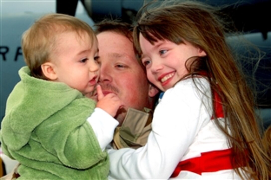 A U.S. Air Force 130th Airlift Wing Air National Guardsman hugs his children upon his return to Air National Guard Base Yeager in Charleston, W.V., after a lengthy deployment to Bagram, Afghanistan, Feb. 18, 2009.