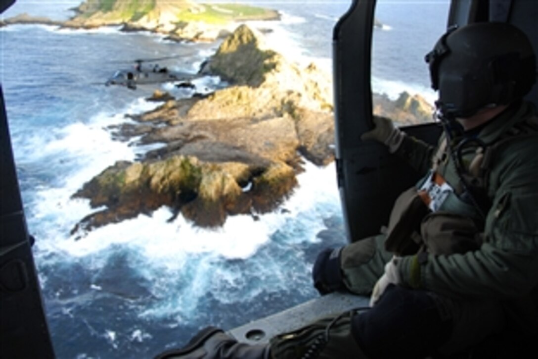 U.S. Air Force Staff Sgt. Andrew Hedin, flying in an HH-60G Pave Hawk helicopter, observes another Pave Hawk over Farallon Island west of San Francisco, Feb. 17, 2009. The helicopters and their crews, from the California Air National Guard's 129th Rescue Wing on Moffett Federal Airfield, Calif., are supporting the U.S. Fish and Wildlife Service by helping transport new photovoltaic batteries to power a lighthouse and workshop at the agency's research facility on the island.