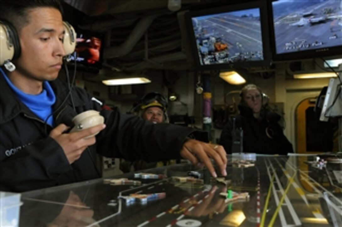 U.S. Navy Petty Officer 2nd Class Philip Gonzales posts the location of aircraft aboard the USS Ronald Reagan (CVN 76) on the ouija board in flight deck control while underway in the Pacific Ocean on Feb. 18, 2009.  The ouija board is a miniature model of the aircraft carrier and shows the position of all the aircraft flying and landing on the ship.  The ship is performing Fleet Replacement Squadron Carrier Qualifications in the Pacific Ocean.  