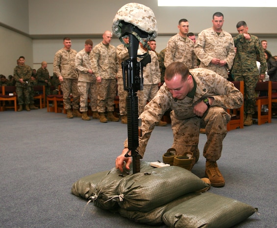 A Marine says a prayer while placing his hand on Staff Sgt. Daniel L. Hansen's display at a memorial service held at Marine Memorial Chapel here Feb. 20. The blast of an improvised explosive device killed Hansen Feb. 14 while he was on deployment in Afghanistan, Hansen was engaged to be married later this year. Photo by Lance Cpl. Chris Kutlesa