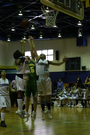 Jessica Bergman goes up between two Osan Cougar defenders for a rebound during the third period of the 2009 Far East Basketball Tournament Girls Class A Championship game held at the IronWorks gym Feb. 20. The tournament was a two-day double elimination event that kicked off Feb. 18 and concluded Feb. 20.