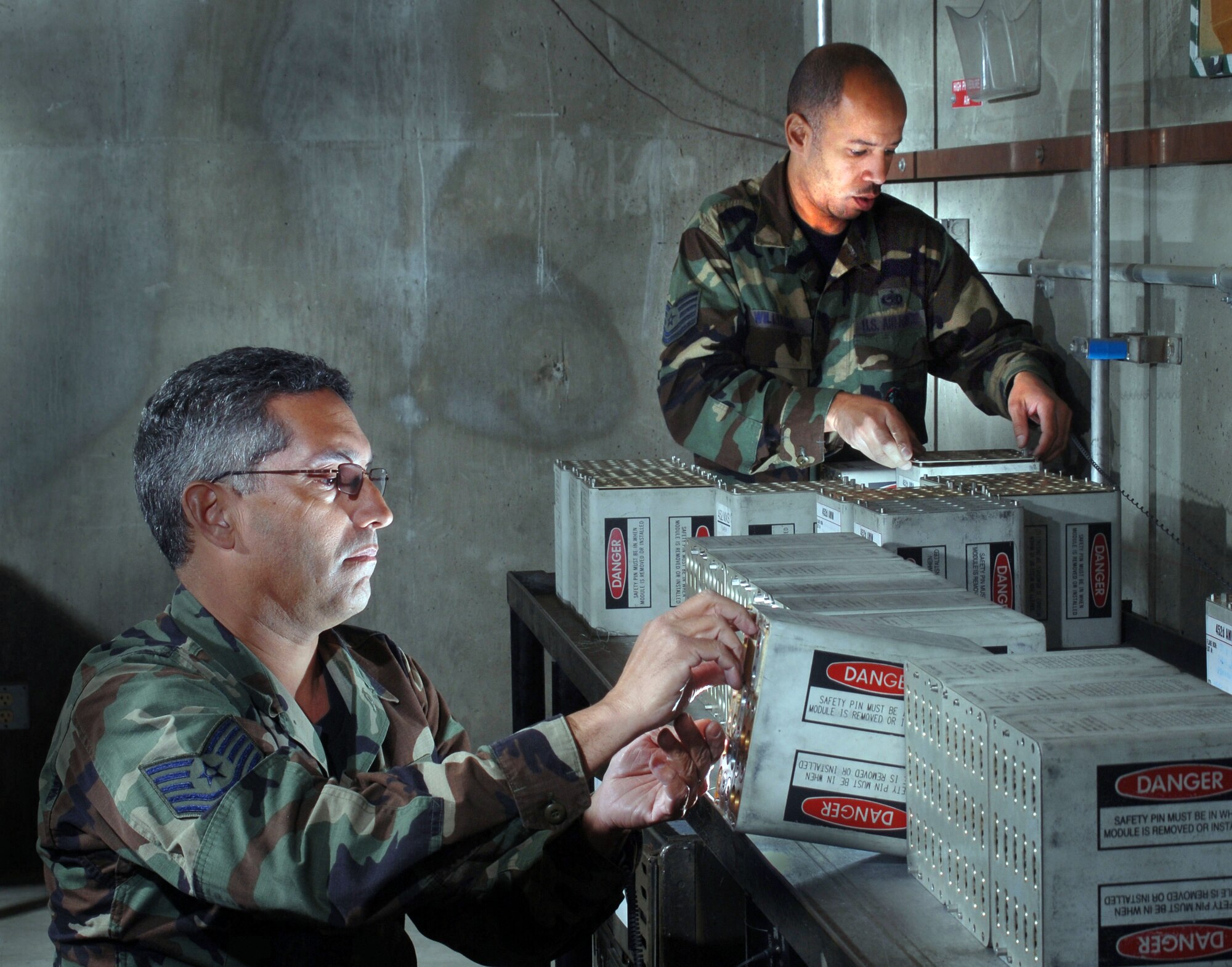 Technical Sgt. Randal Williams, right, assembles flares on an ammunition containers while Technical Sgt. Sergio Hernandez, left, reloads C-17 Globemaster III aircraft countermeasures flares into magazines at the base on February 18. Both are air reserve technicians with the 452nd Maintenance Squadron’s Munitions Flight. (U.S. Air Force photo by Val Gempis)