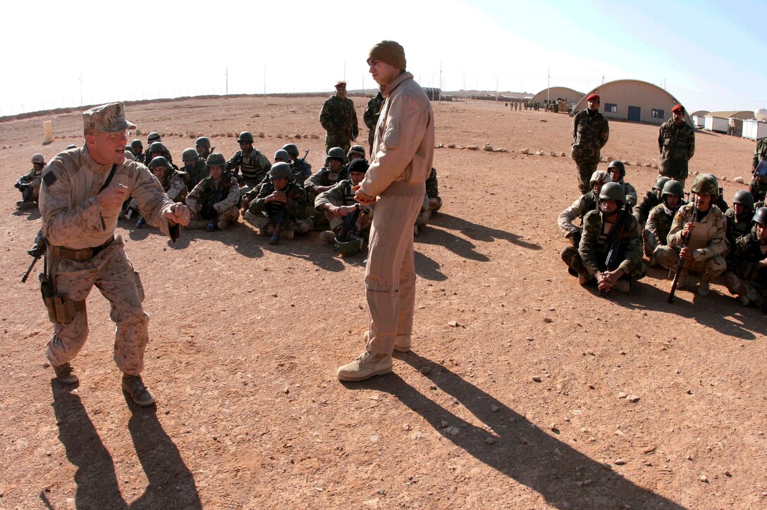 With the assistance of Xian, an Arabic interpreter, Staff Sgt. Timothy Wenrich (left), a platoon sergeant with Company E, 2nd Battalion, 25th Marine Regiment, Regimental Combat Team-8, teaches a class about infantry fire and movement techniques to soldiers from the 3rd Battalion, 29th Brigade, 7th Iraqi Army Division Feb. 23, 2009.  Wenrich, a game warden in his civilian career, is on his second tour to Iraq.