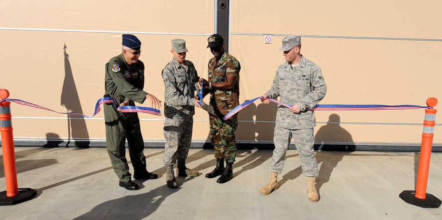 MOODY AIR FORCE BASE, Ga. -- Col. Kenneth Todorov, 23rd Wing commander, Airman Bradley Nickel, 23rd Component Maintenance Squadron, fuels systems apprentice, Col. Darrell Mosley, 23rd Maintenance Group commander and Airman 1st Class John Music, 23rd Component Maintenance Squadron, fuels systems apprentice officially open  the new A-10C Thunderbolt II two-bay fuel cell maintenance hangar during a ceremony here Feb.19. The fuel cell hangar will support the maintenance of the A-10Cs that perform close air support missions. (U.S. Air Force photo by Airman Joshua Green) 