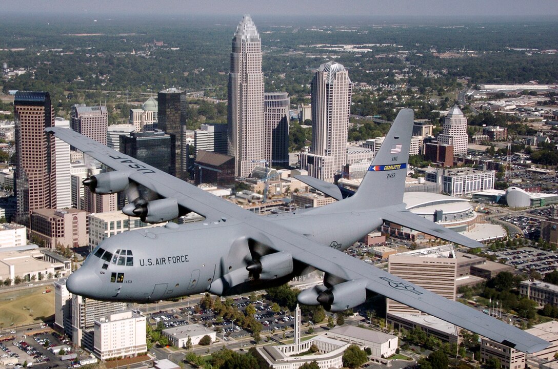 A C-130 Hercules flies over the city of Charlotte, N.C. displaying the new tail markings. The updated tail has "Charlotte" in yellow, along with a logo used back in the 1950s, when the North Carolina Air National Guards mission was flying the F-86 Sabre fighter jet. (U.S. Air Force photo/Tech. Sgt. Brian E. Christiansen) 