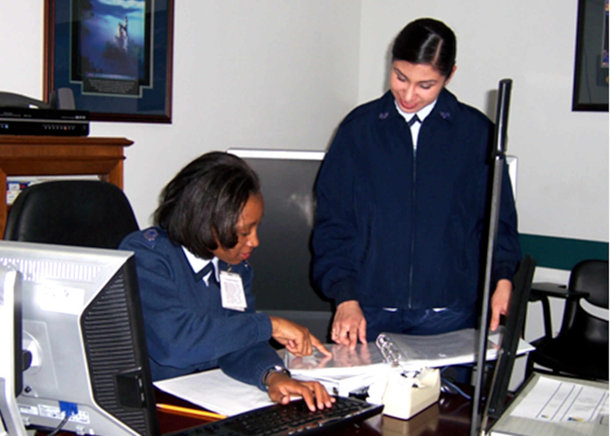 CANNON AIR FORCE BASE, N.M. - Master Sgt. Andrea Lee and Senior Airman Velia Bravo, 27th Medical Operations Group, assemble binders in preparation for a triennial Health Services Inspection, Feb. 9-13. Of the 16 categories inspected, the group received eight "outstanding," three "excellent" and five "satisfactory" ratings. (Courtesy photo)