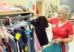 Holly Blake hangs clothing items at the Randolph Thrift Shop on Feb. 20. (U.S. Air Force photo by Steve White)